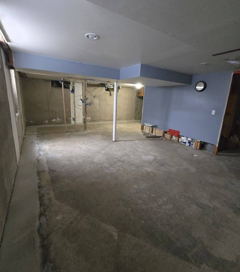 Completed sump pump installation in a finished Michigan basement